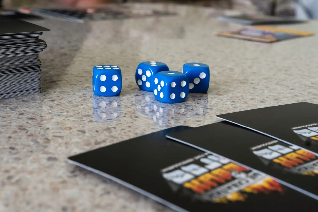 Würfel und Spielkarten auf einem Holztisch angeordnet