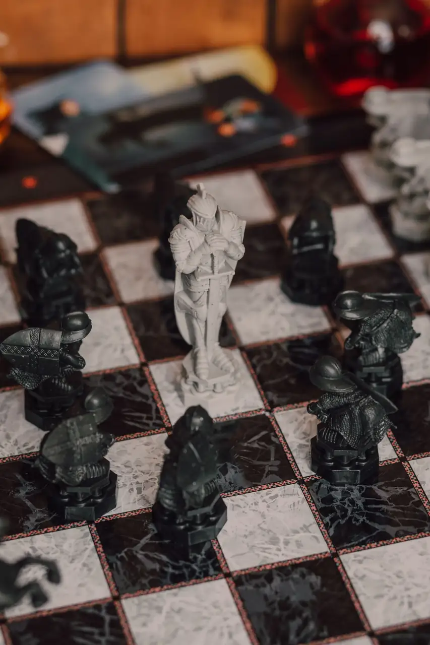 Miniatur-Zauberer und filigrane Spielfiguren auf einem Strategiespielbrett